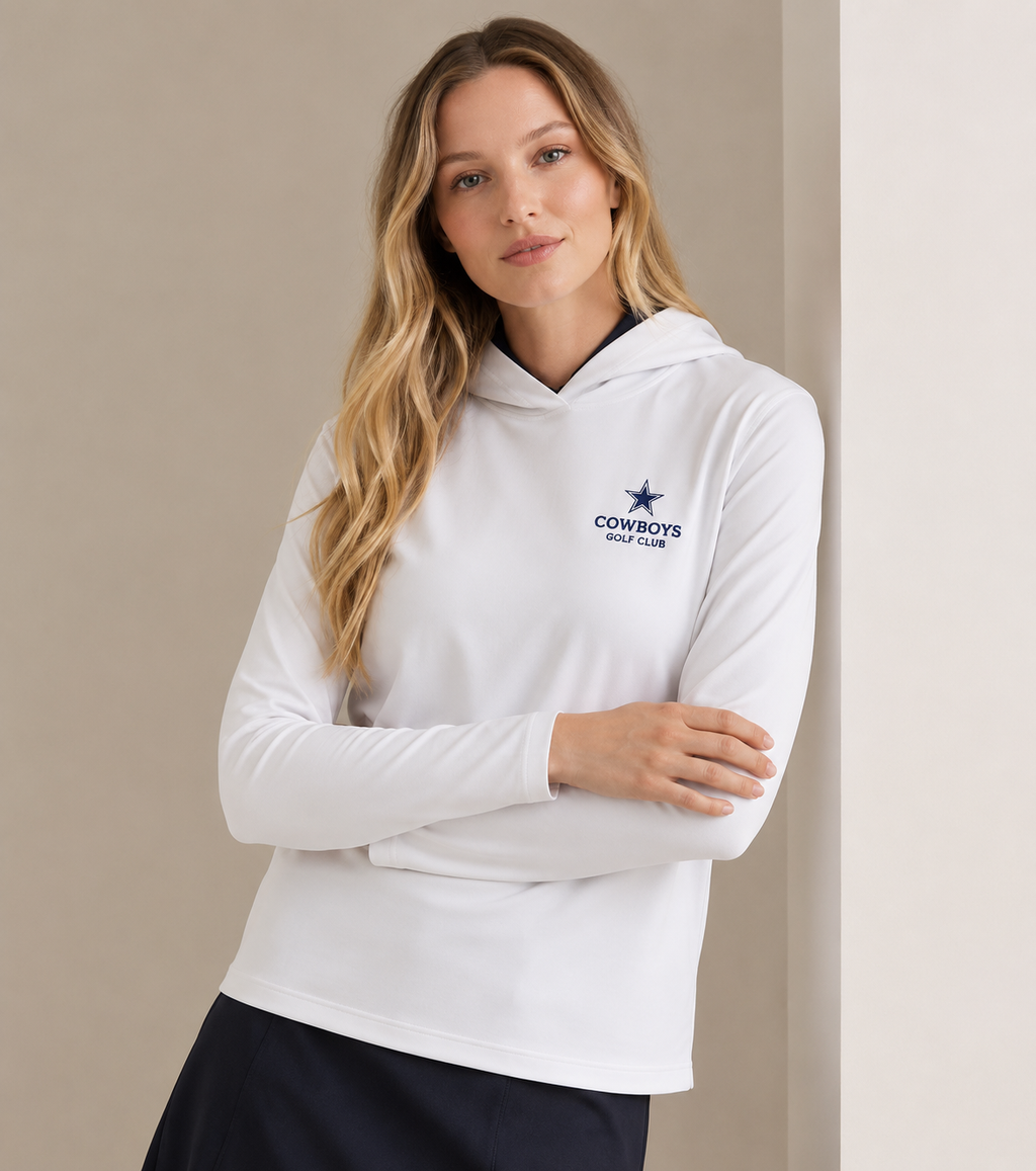 Woman wearing a white hoodie with the Cowboys Golf Club logo on a beige background